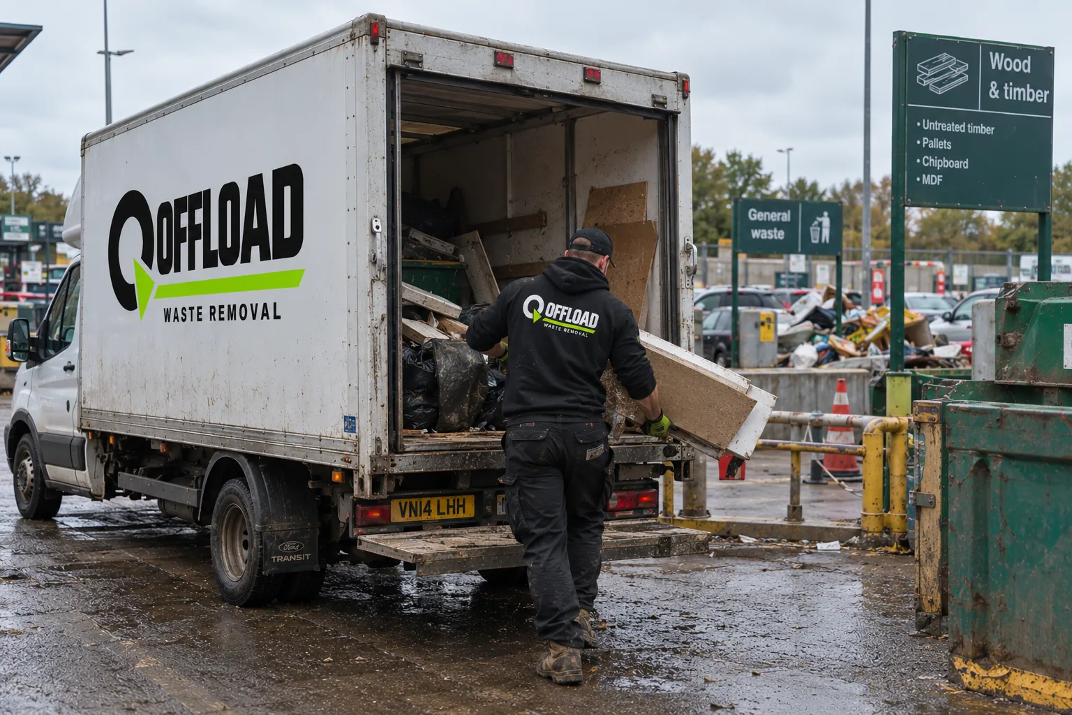 Offload crew member carrying timber and board out of a waste removal van in Leeds